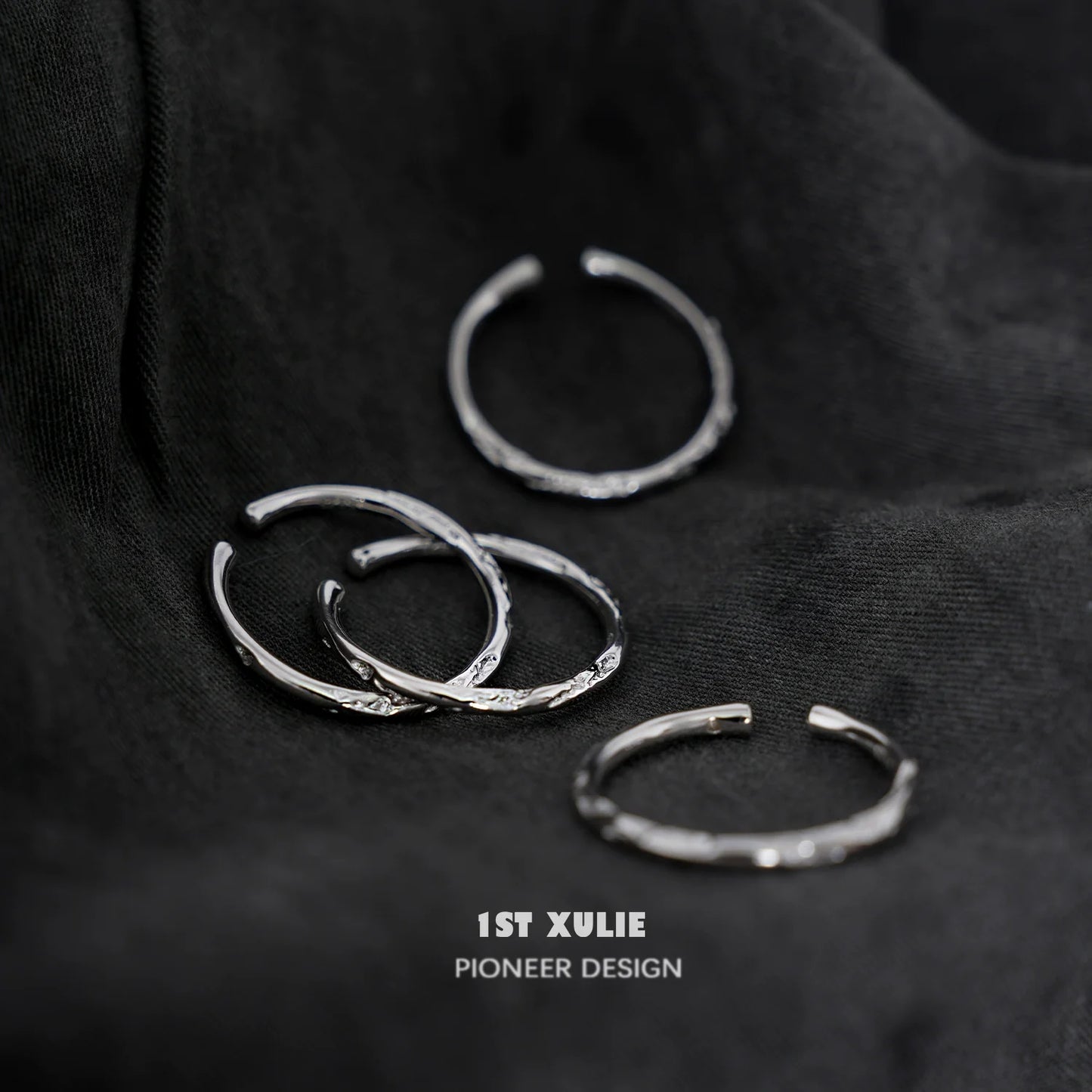 Set of four elegant textured silver rings with unique designs, perfect for stacking or solo wear