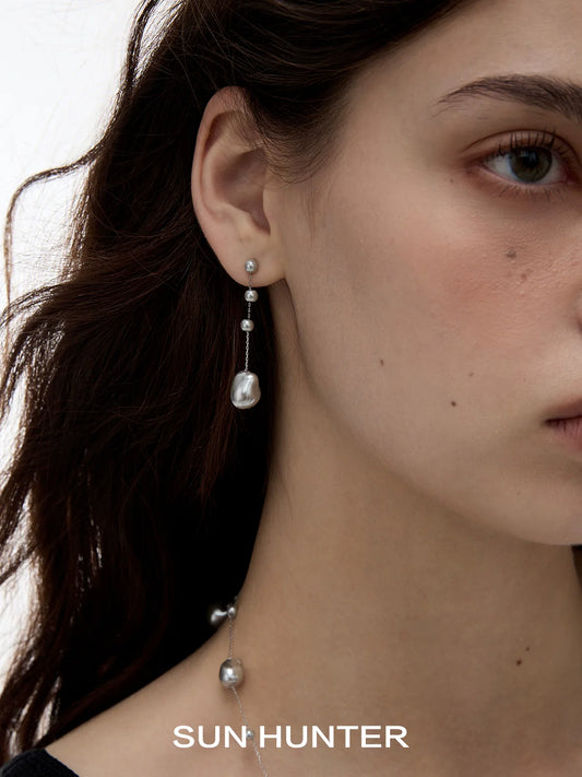 Elegant SUN HUNTER baroque pearl earrings featuring a unique drop design with shimmering pearls