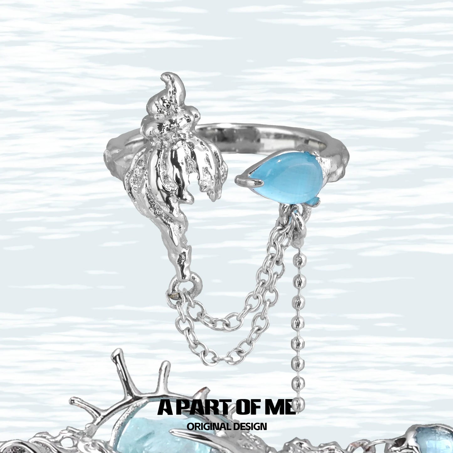 A PART OF ME blue conch chain ring with a silver finish and blue gemstone detail