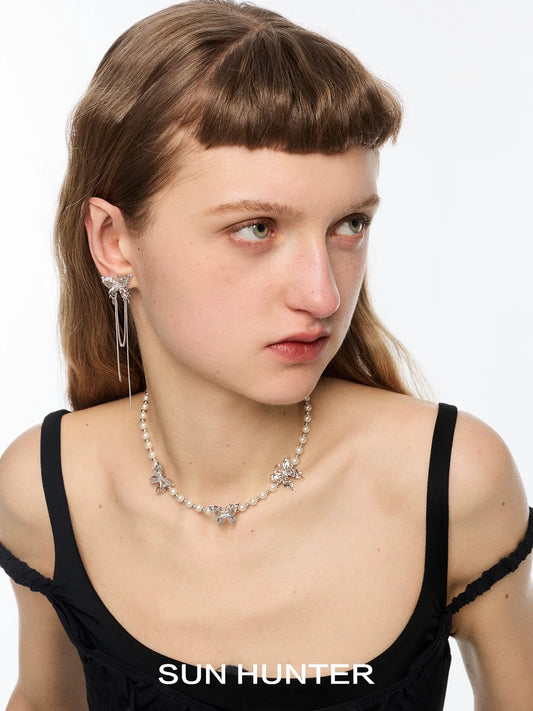 SUN HUNTER butterfly tassel ear cuffs with elegant chain detailing showcased on model