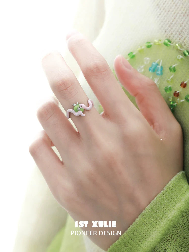Cute snake silver ring designed by 1ST XULIE with colorful accents on a hand model