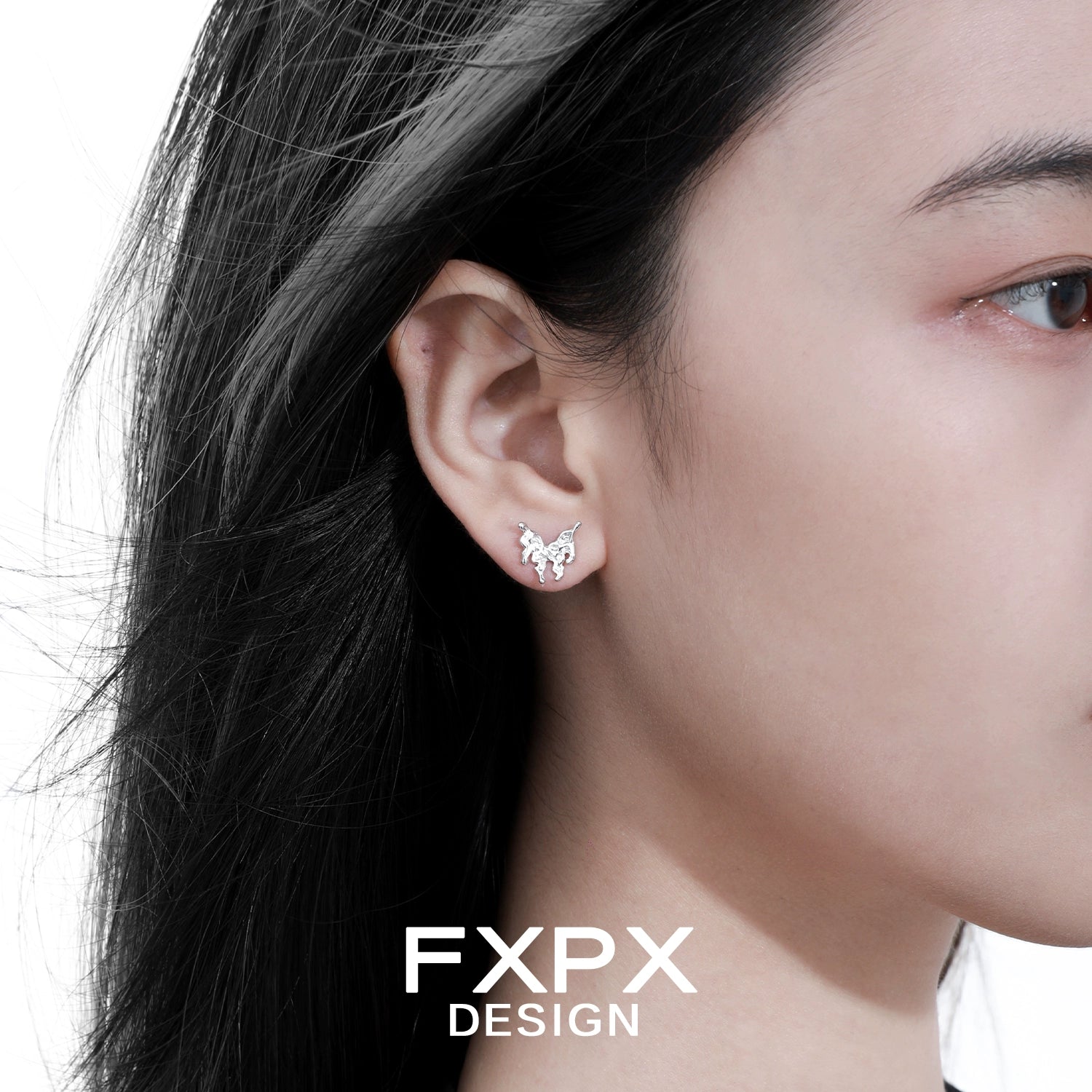 Close-up of a woman wearing Bloody Doll Jewelry cyber butterfly earrings in silver by FXPX