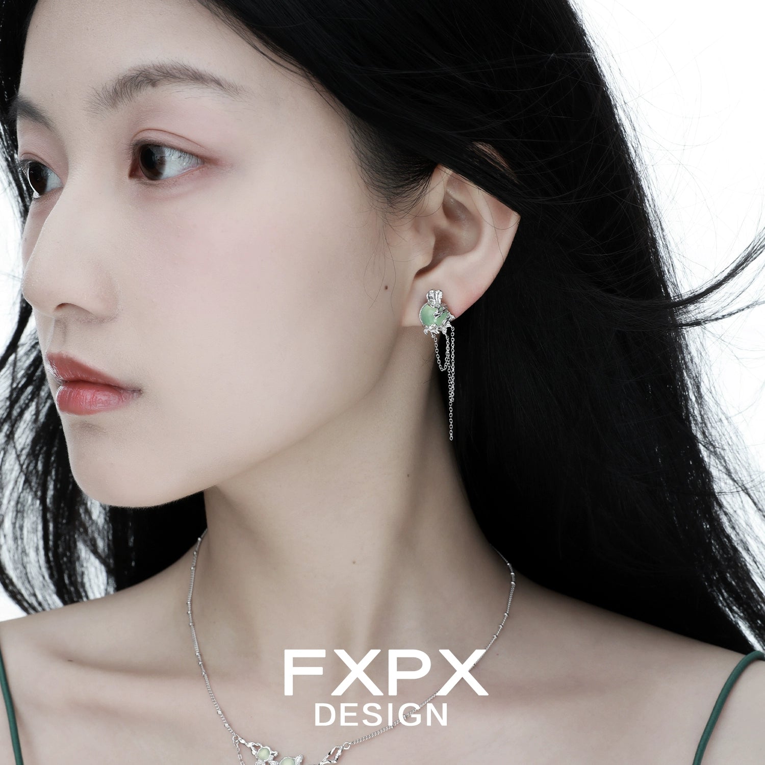 Close-up of a woman wearing Bloody Doll Jewelry gentle green agate tassel earrings by FXPX