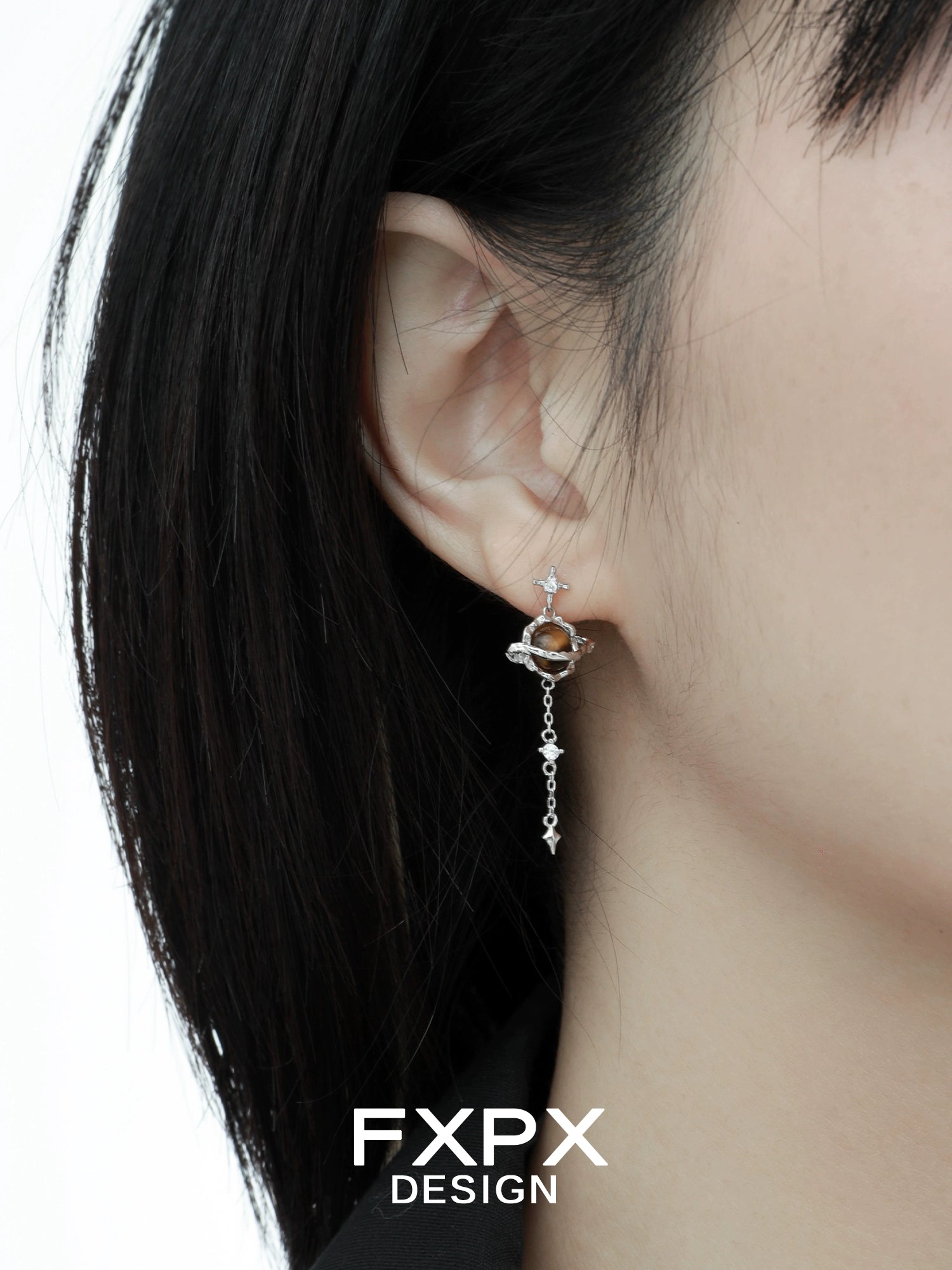 Bloody Doll Jewelry Gothic Saturn tiger eye earrings with silver planet design worn on ear