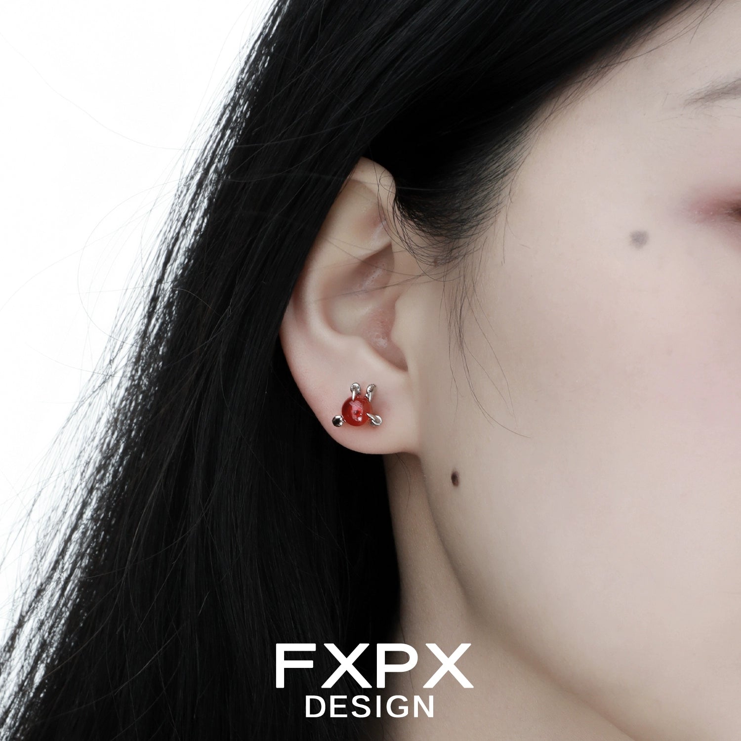 Close-up of bloody dragon claw gothic earrings worn on ear with black hair and pale skin