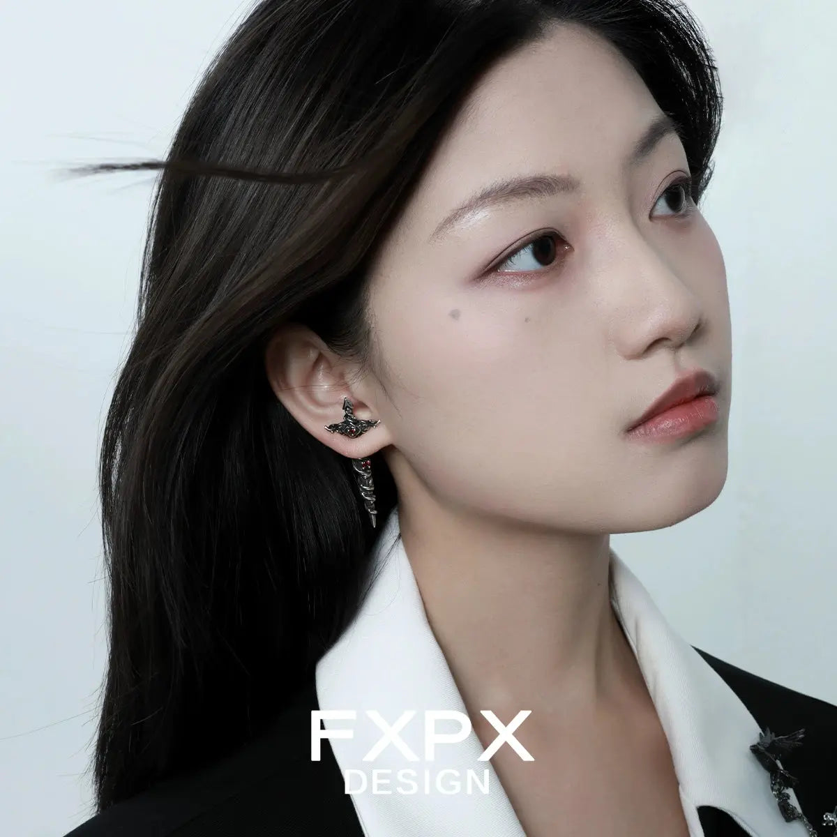 Woman wearing gothic rose red zircon earrings by FXPX with a stylish black and white outfit