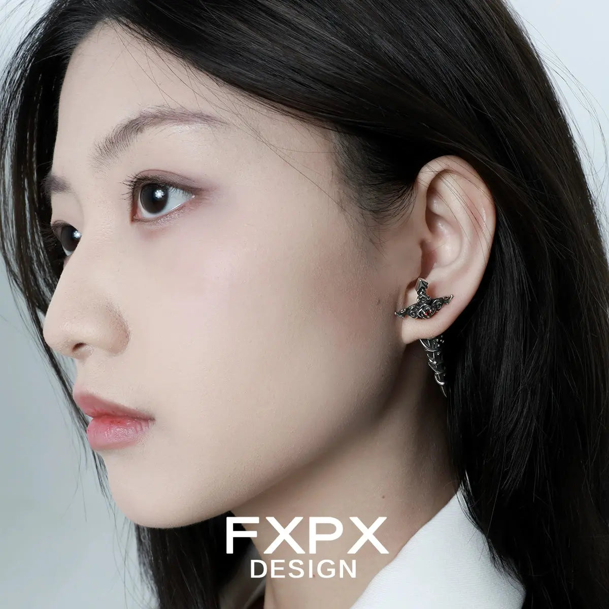 Close-up of a woman wearing gothic rose red zircon earrings by FXPX with intricate rose design