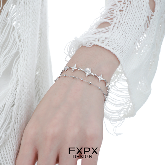 Elegant FXPX star silver bracelet with delicate star charms on a model's wrist