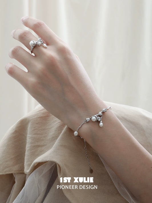 Elegant lily of the valley pearl bracelet on hand, showcasing delicate floral design and lustrous pearls