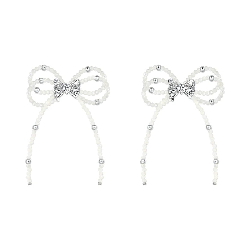SUN HUNTER pearl bow ribbon earrings featuring elegant design with silver accents and delicate pearls
