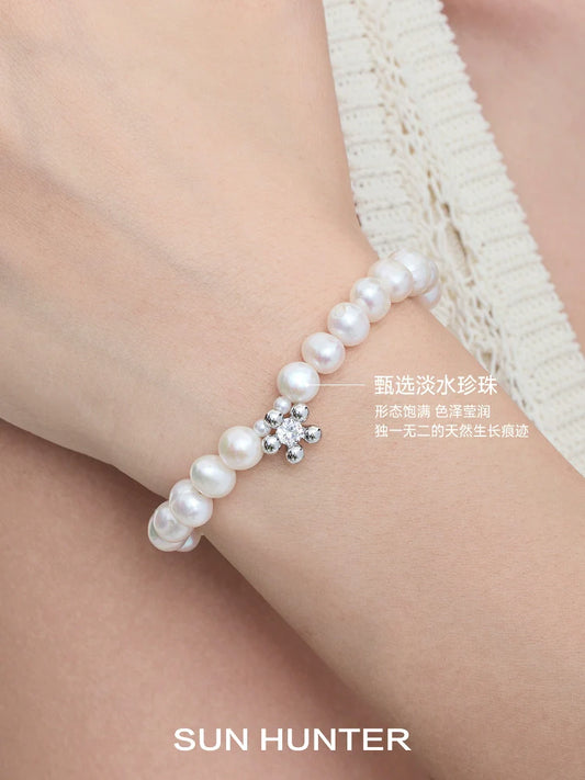 Elegant SUN HUNTER pearl bracelet for women featuring natural pearls and a sparkling flower design