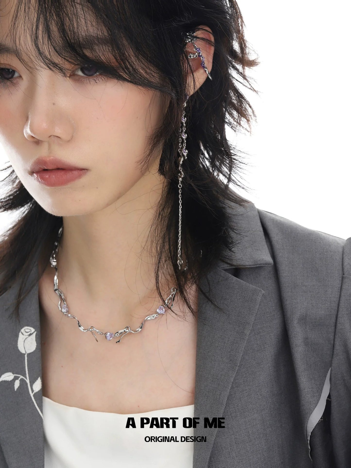 Model wearing a silver necklace alongside a purple rose goddess ring from A PART OF ME