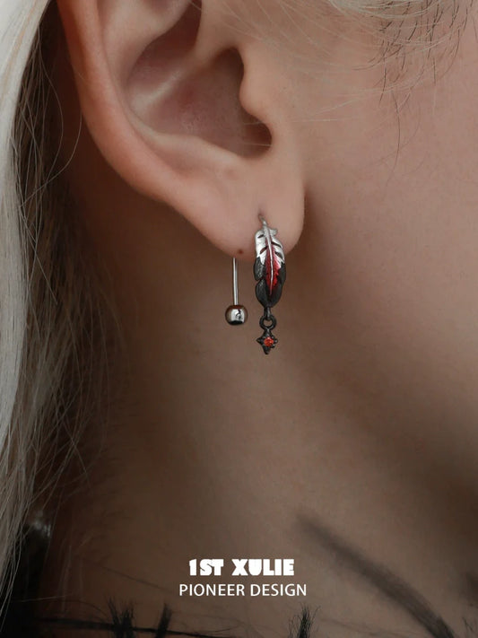Red feather earrings with a unique design featuring silver accents and a stylish hook for an elegant look