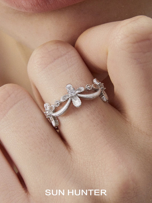 Elegant SUN HUNTER shimmer cross ring with delicate floral design and sparkling accents