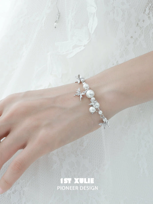 White butterfly pearl bracelet with elegant silver accents on a model's wrist