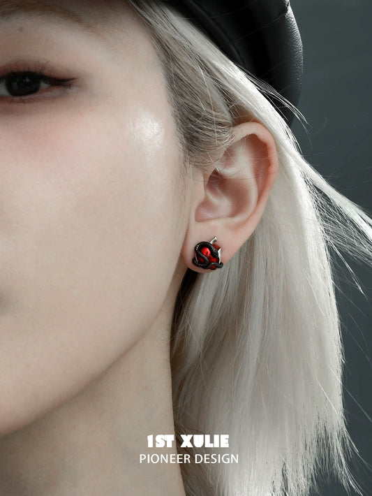 Wicked apple snake ear studs worn on a model's ear, showcasing unique design with vibrant colors