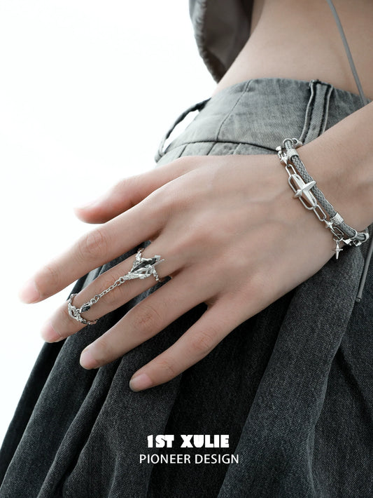 Y2K punk silver ring displayed on a model's hand with a trendy outfit and accessories