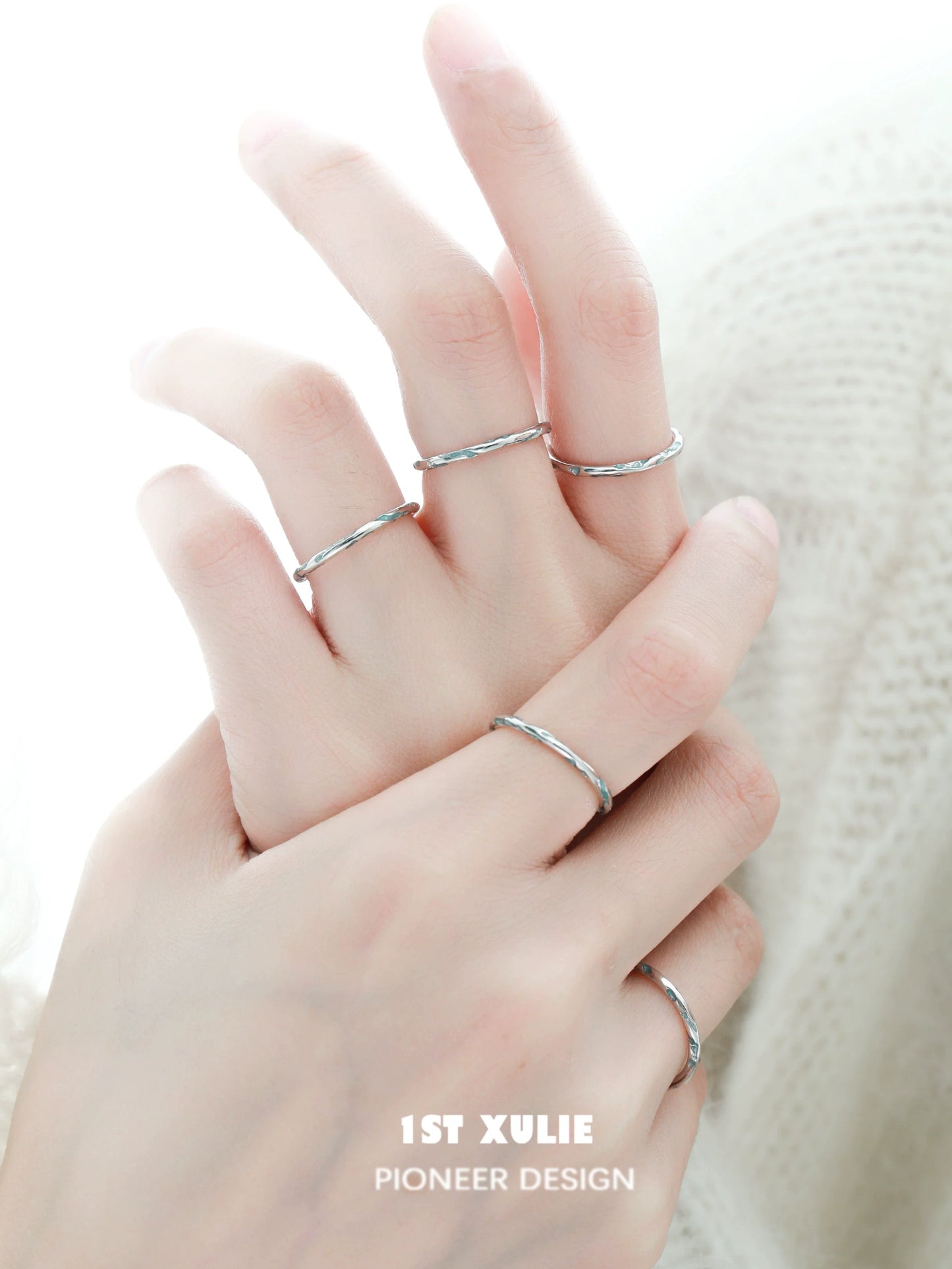 Set of delicate rings featuring a blue textured silver ring among minimalist designs
