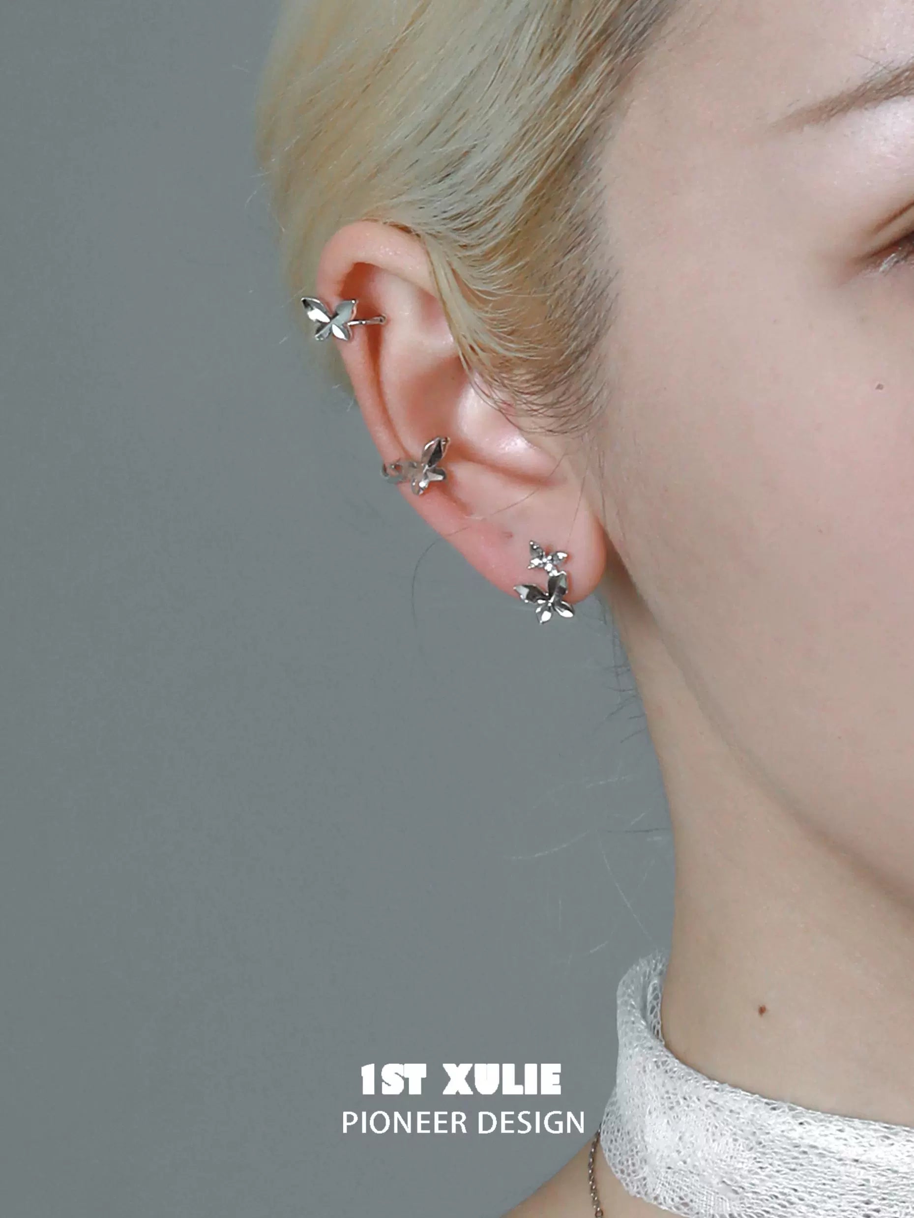 Stylish butterfly silver ear cuff showcased on a model's ear with minimalist design.