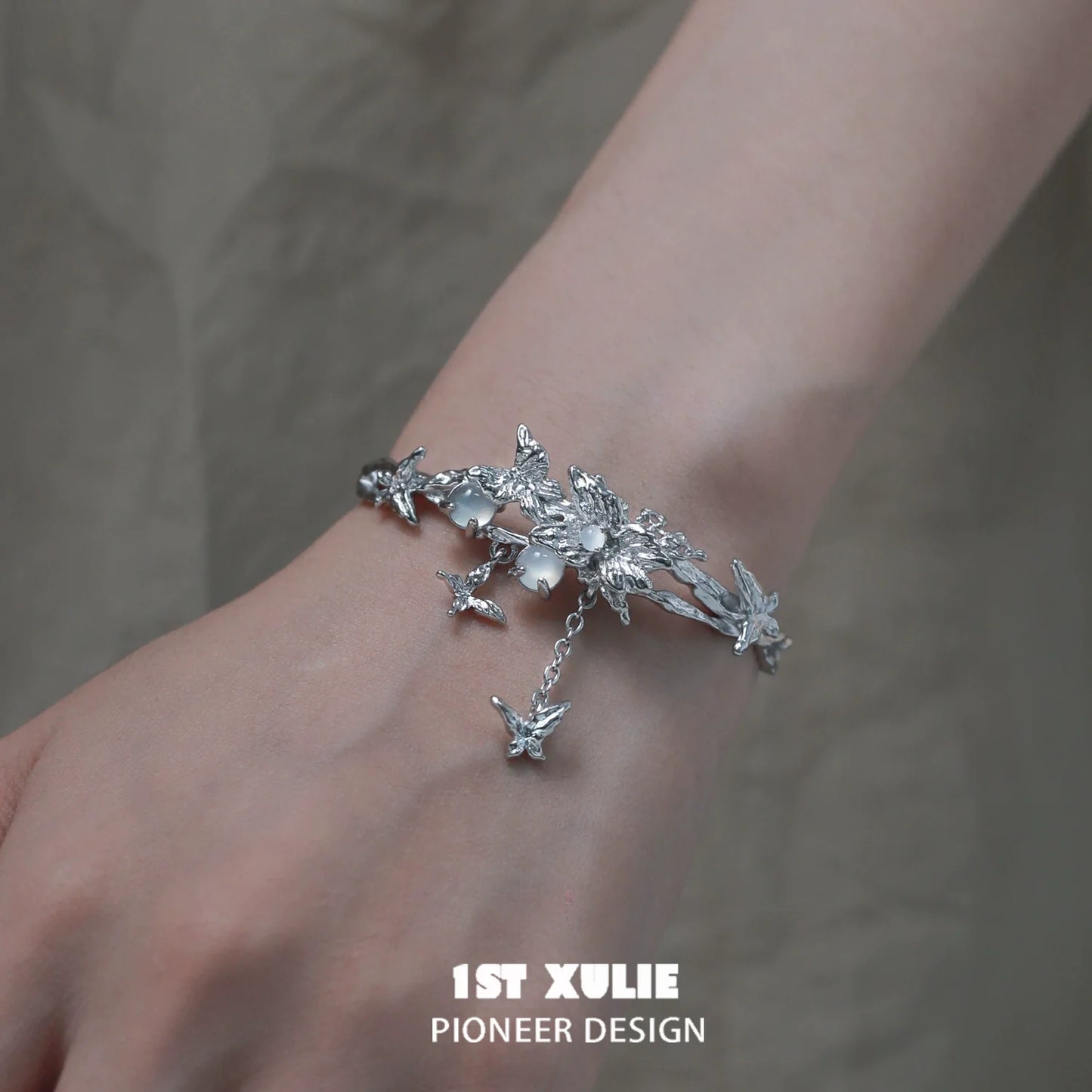 Butterfly tassel white agate bracelet with intricate floral design worn on a hand