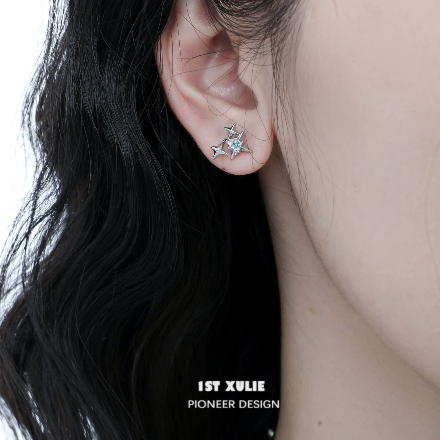 Elegant cat star stud earrings in silver showcased on a model's ear