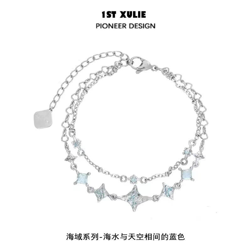 Double layer starfish silver bracelet featuring shimmering blue accents and a delicate chain design