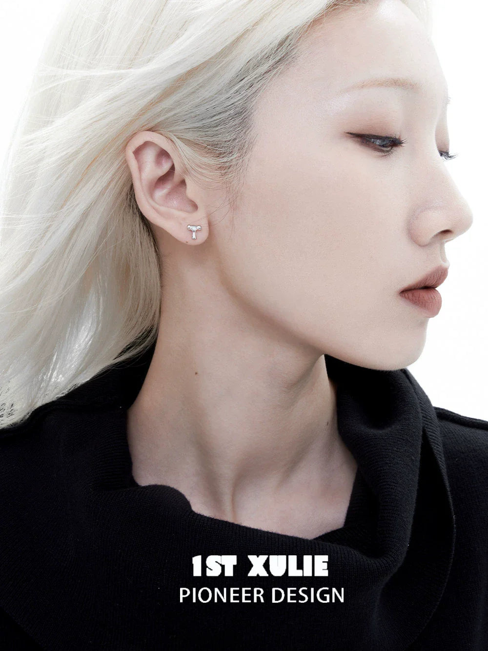 Edgy letter silver stud earrings featured on model with sleek hairstyle and minimal makeup