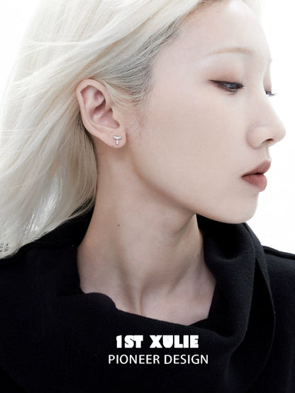 Edgy letter silver stud earrings featured on model with sleek hairstyle and minimal makeup
