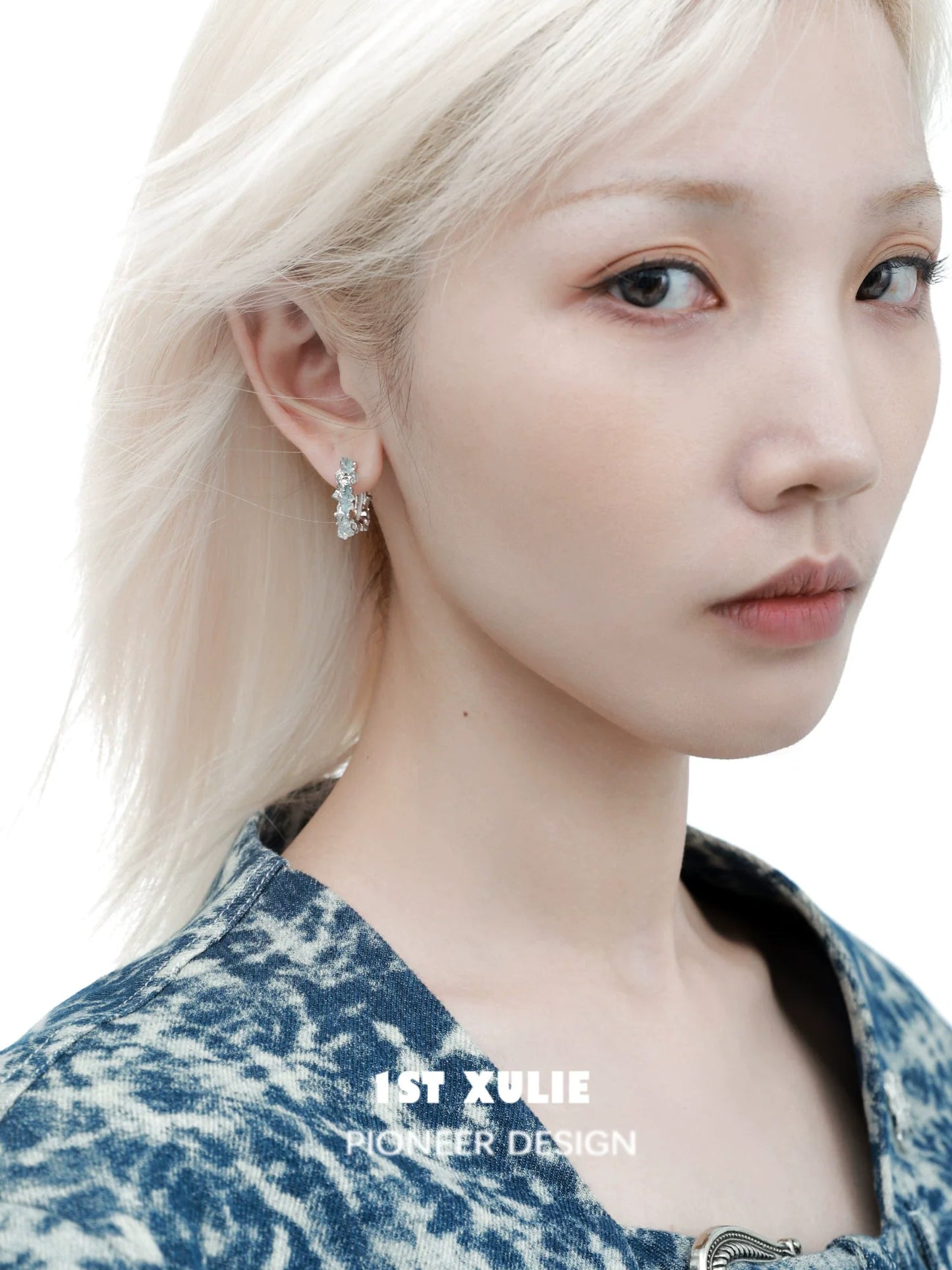 A model wearing 1ST XULIE frozen blue crystal ear cuffs with a fashionable hairstyle and outfit