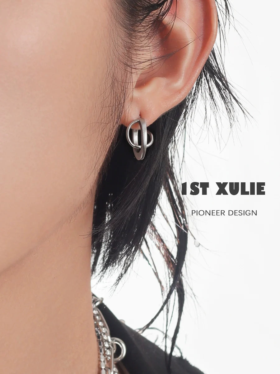 Futuristic silver geometric earrings showcased on a model's ear for a modern fashion statement