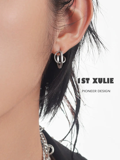 Futuristic silver geometric earrings showcased on a model's ear for a modern fashion statement