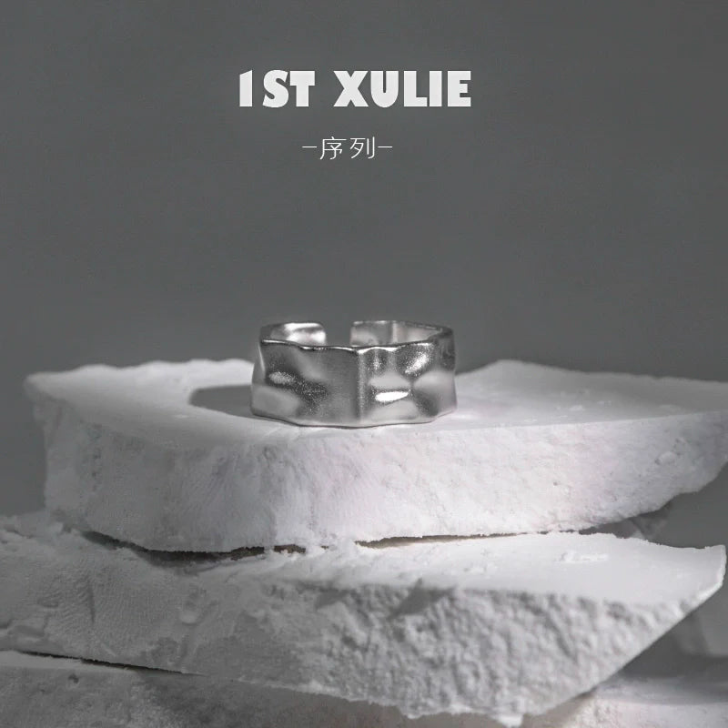 Futuristic silver ring displayed on a textured stone surface for modern fashion enthusiasts