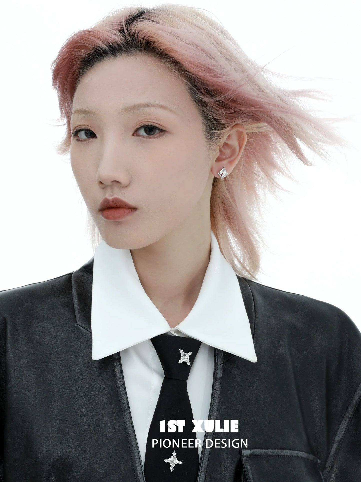 Geometric silver earrings showcased on a model with stylish hair and outfit