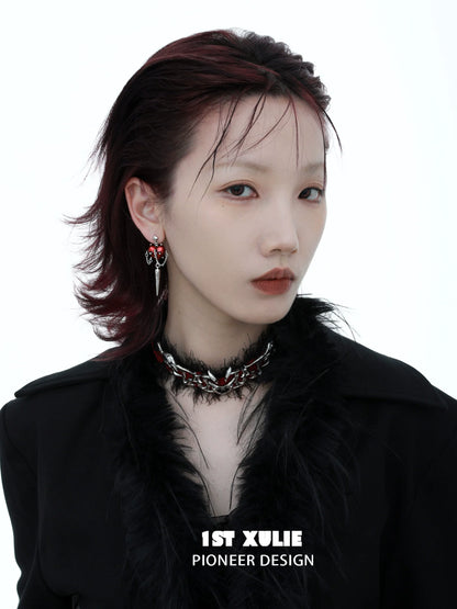 Model wearing gothic heart earrings and a black feather choker showcasing a bold fashion statement