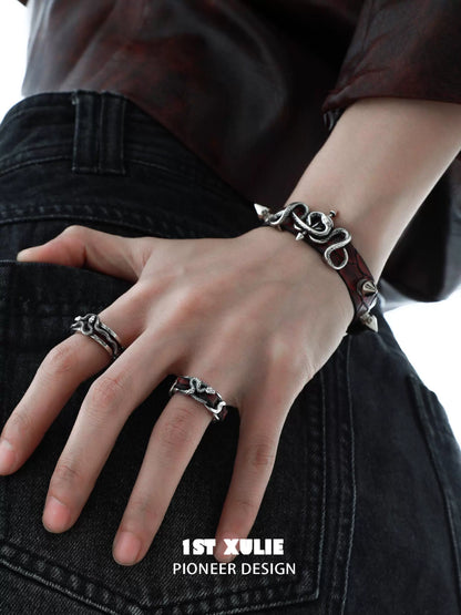 Gothic snake bracelet in silver and leather, styled on a hand with bold rings for a trendy look