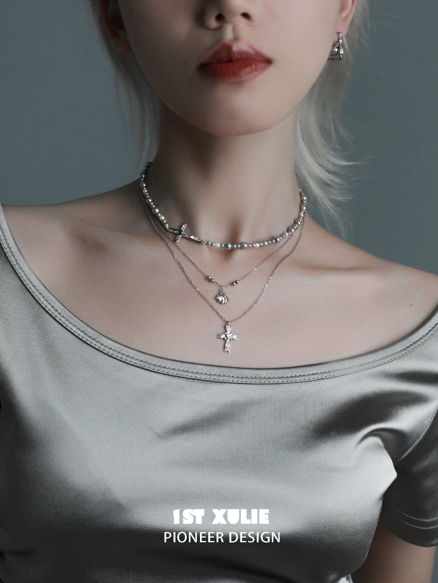 Elegant gray pearl silver double layer necklace with delicate charms worn over a soft satin top