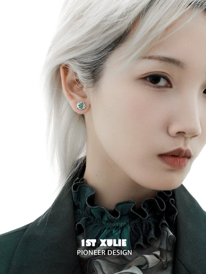 Model wearing green serpent ear cuffs featuring intricate design and elegant style