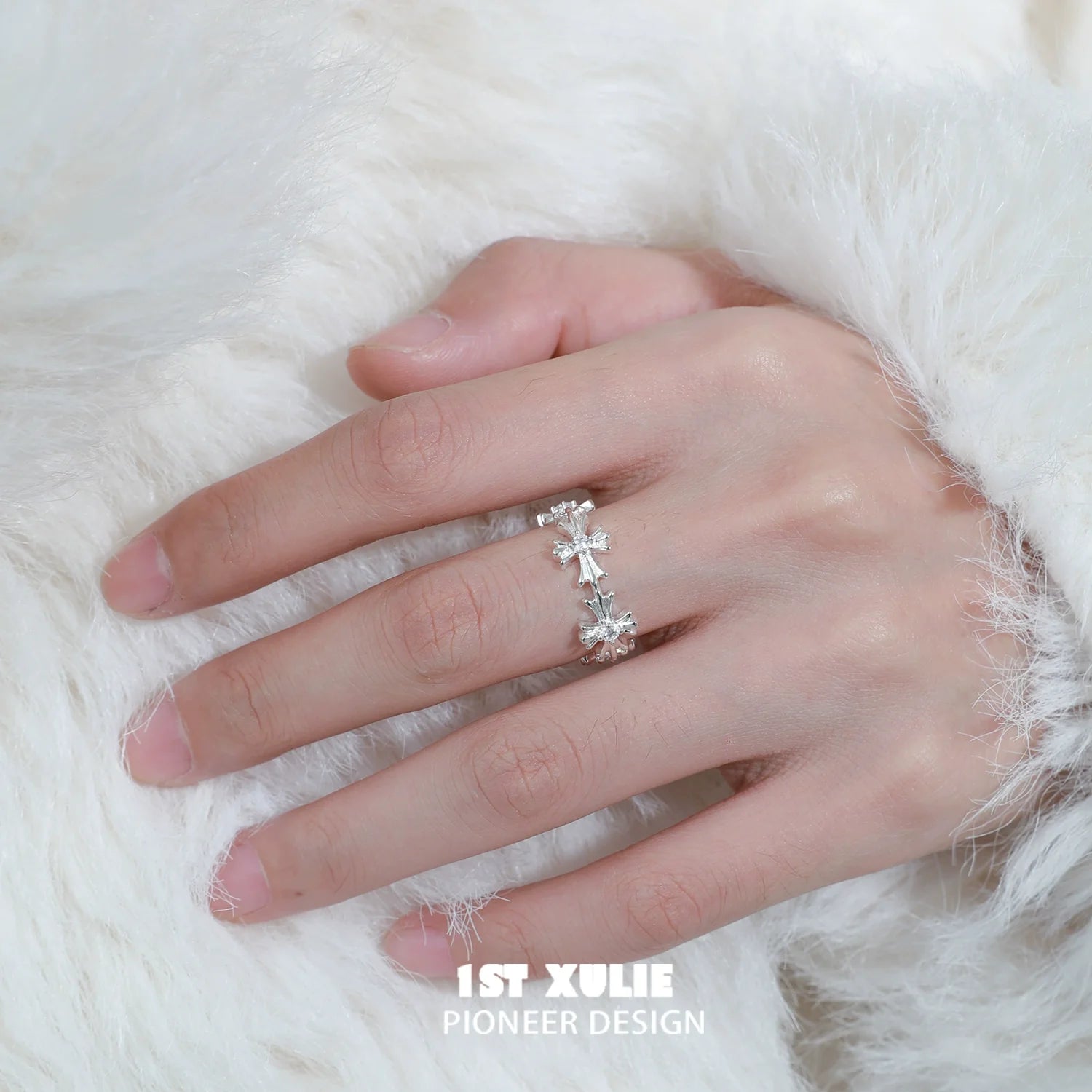 Holy light cross silver ring featuring intricate design worn on a hand with a soft fur background