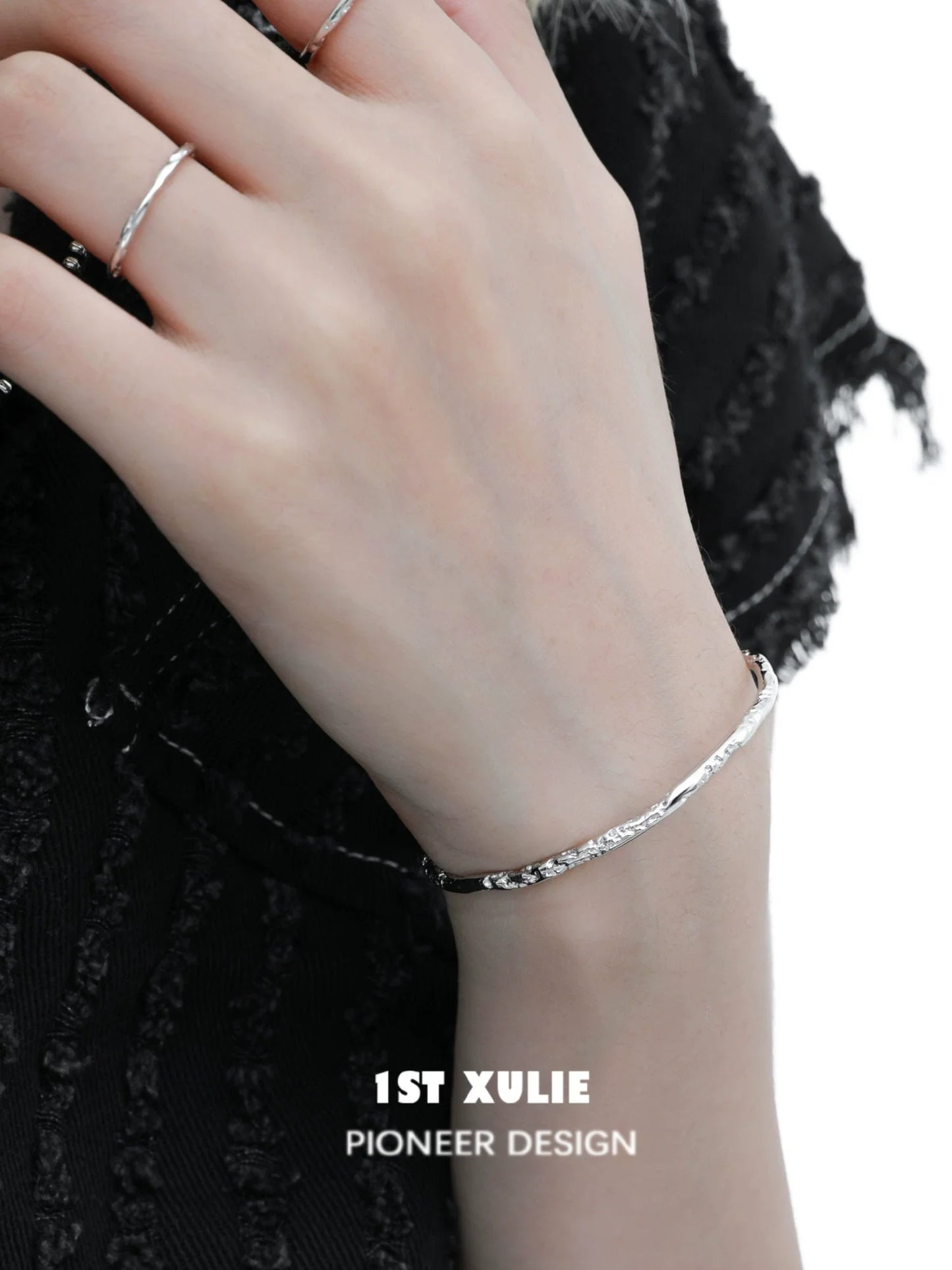 Stylish minimalist silver bracelet worn on the wrist, showcasing a sleek design by 1STXULIE