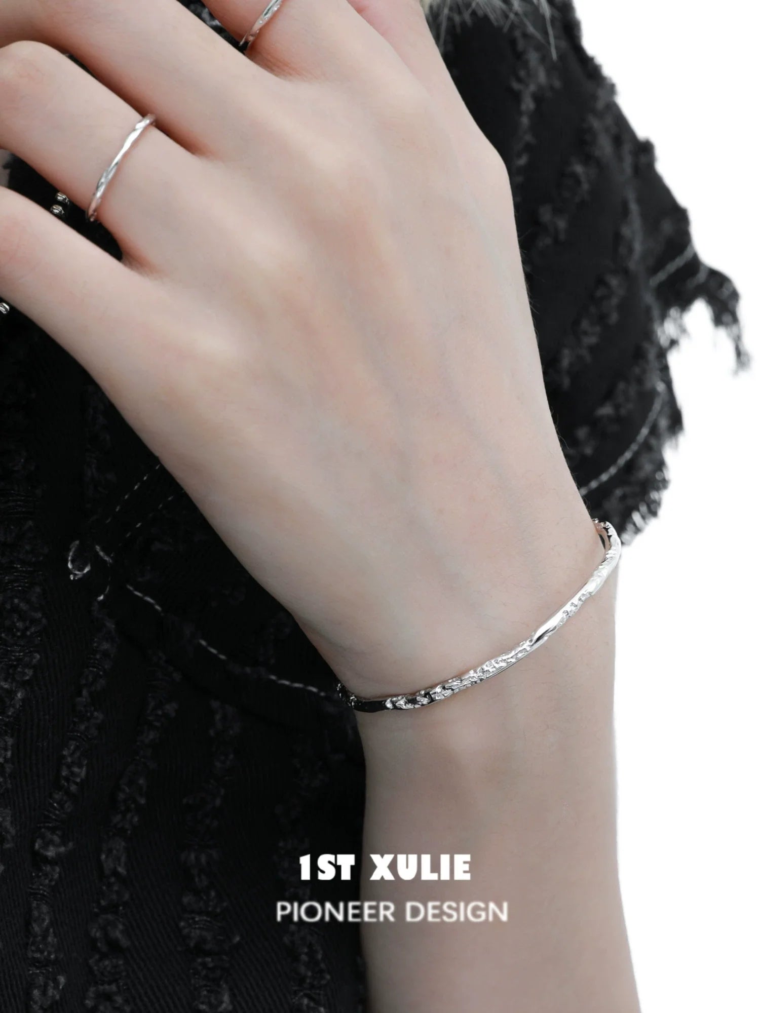 Stylish minimalist silver bracelet worn on the wrist, showcasing a sleek design by 1STXULIE