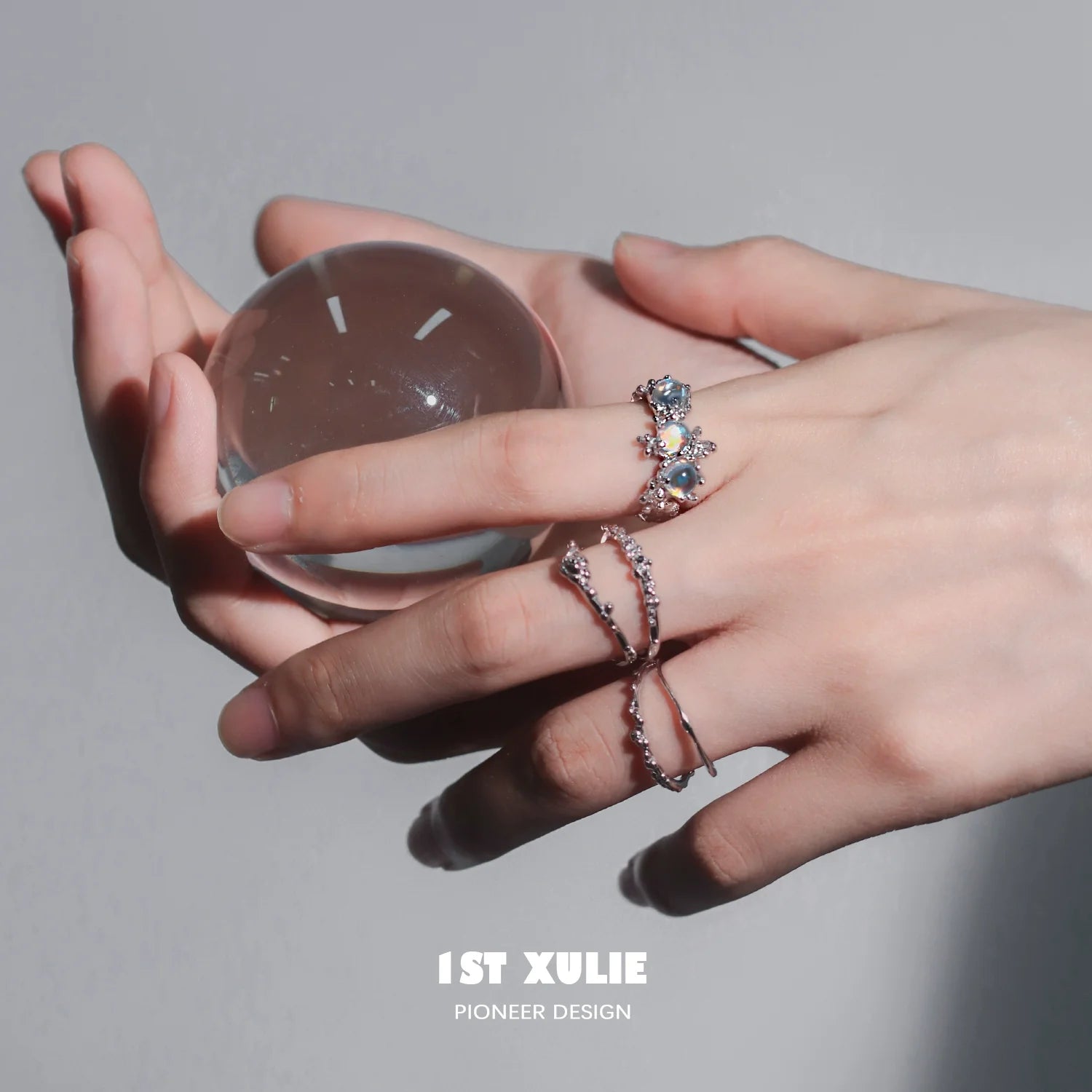 Elegant moonstone silver ring featuring intricate design, showcased on a hand holding a crystal ball