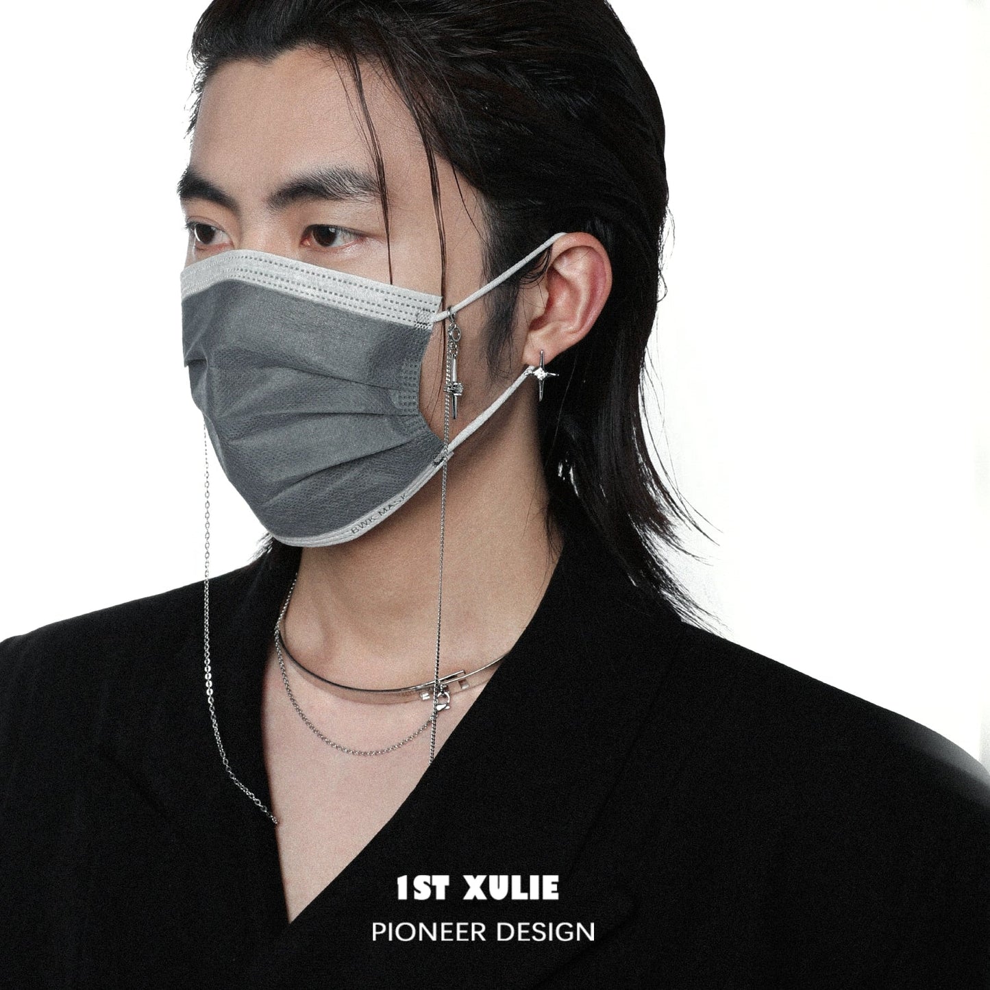 Model wearing a gray face mask and stylish mystic star necklace layered with silver chains