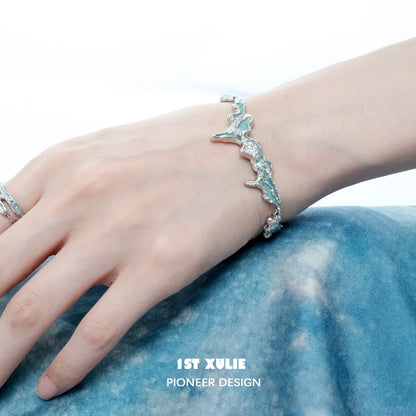 Mystical blue silver bracelet elegantly displayed on a model's wrist with a soft fabric background
