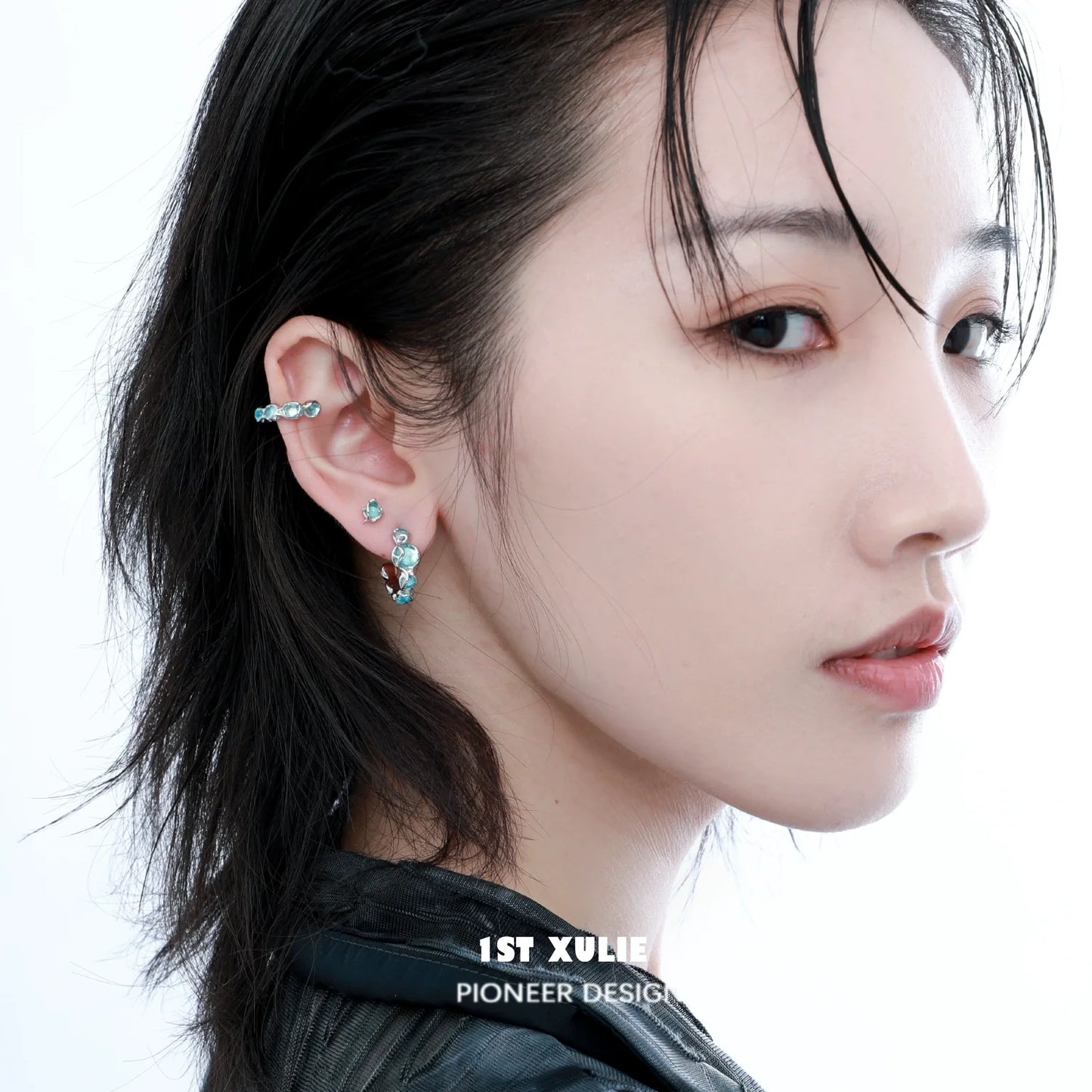 Elegant ocean blue stud earrings showcased on a model's ear, highlighting their unique design and color