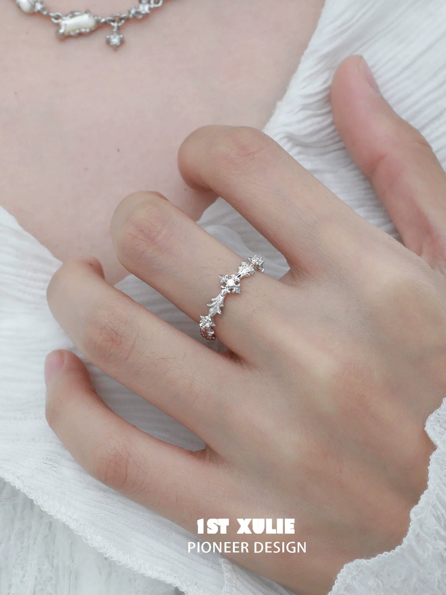 Elegant silver cross couple rings designed by 1STXULIE, featuring shimmering stones for a romantic touch