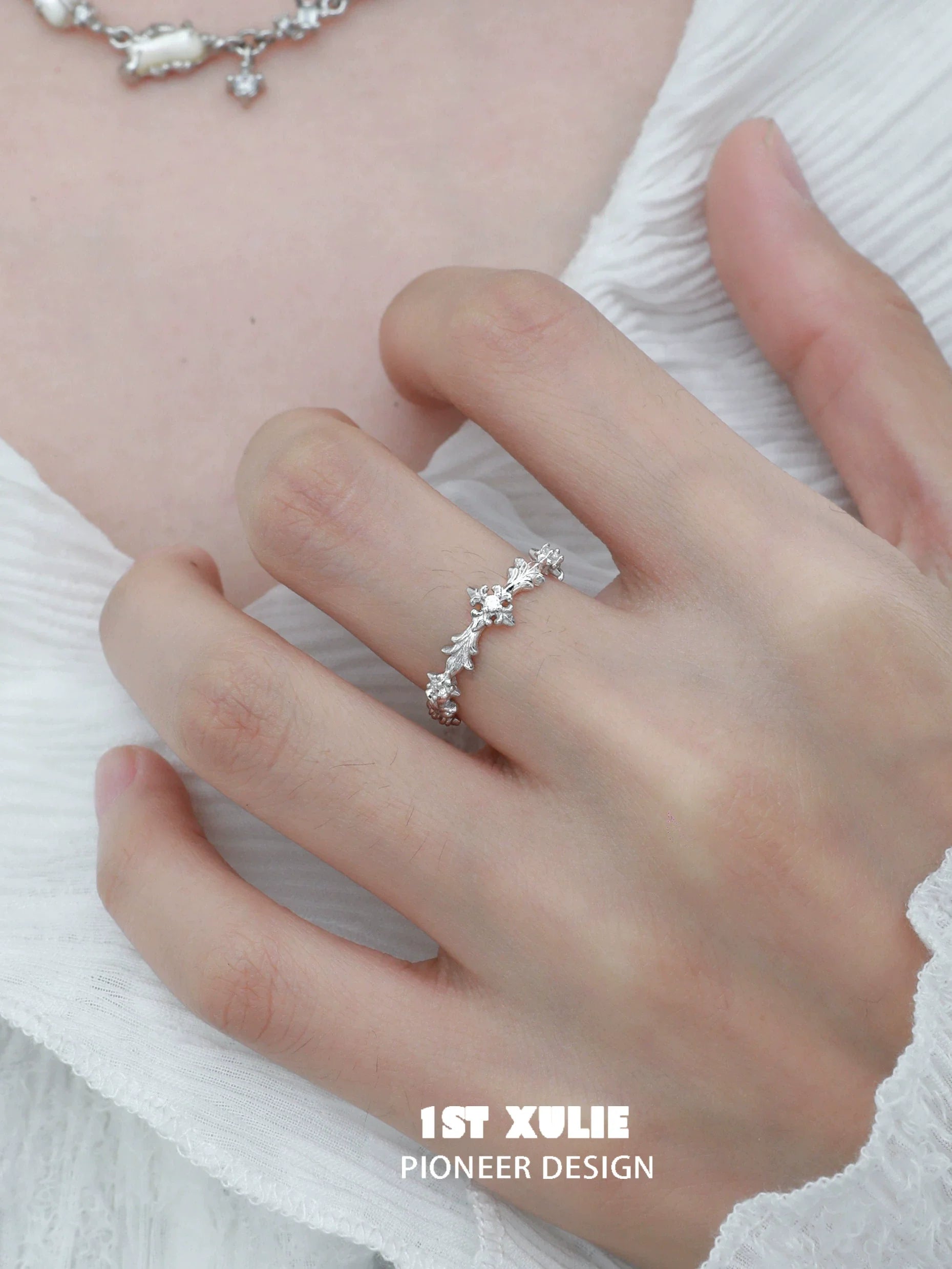 Elegant silver cross couple rings designed by 1STXULIE, featuring shimmering stones for a romantic touch