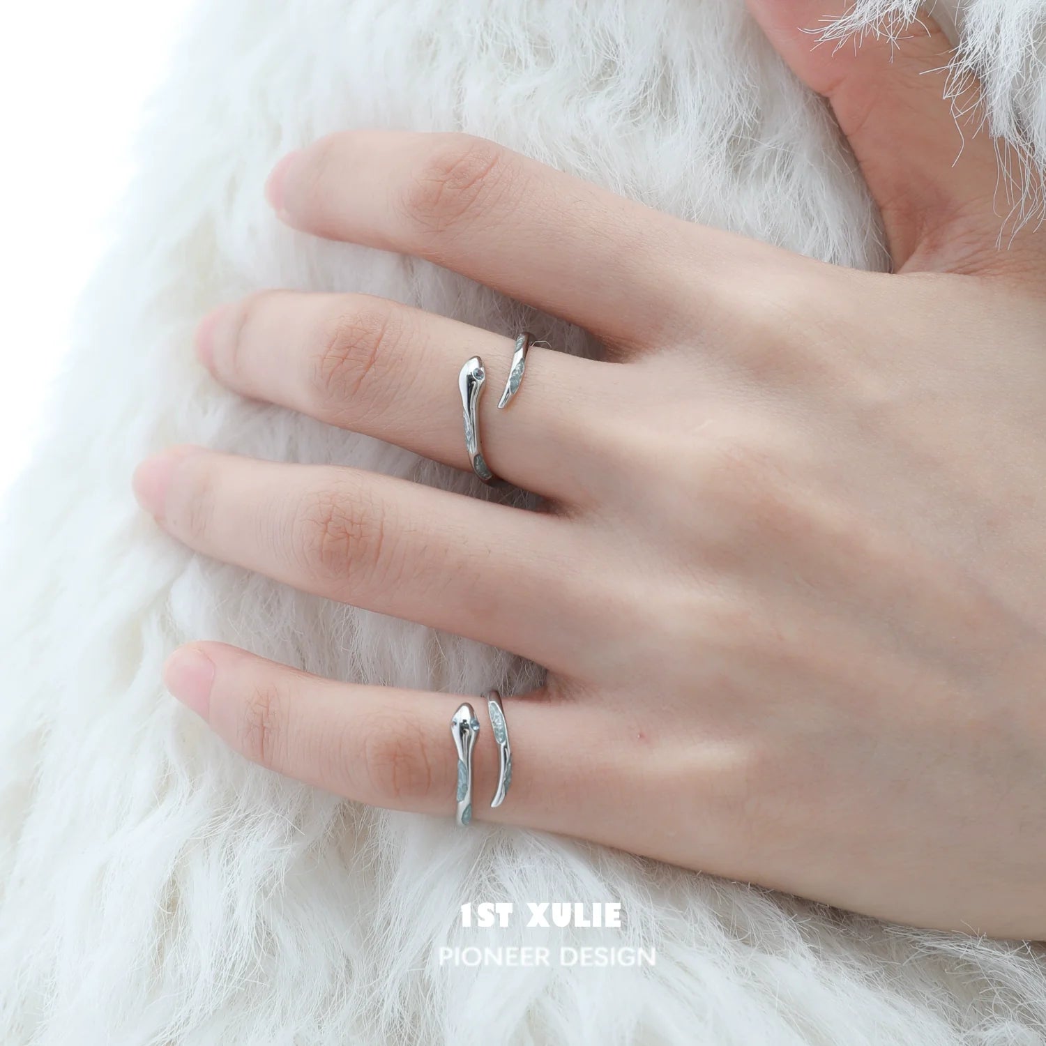 Silver snake ring featuring a sleek design, worn on a hand with delicate fingers
