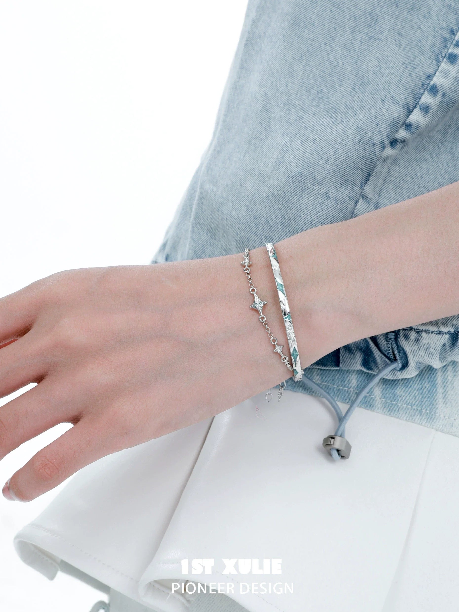 Elegant silver starlight bracelet on a hand, paired with a chic outfit for a stylish look