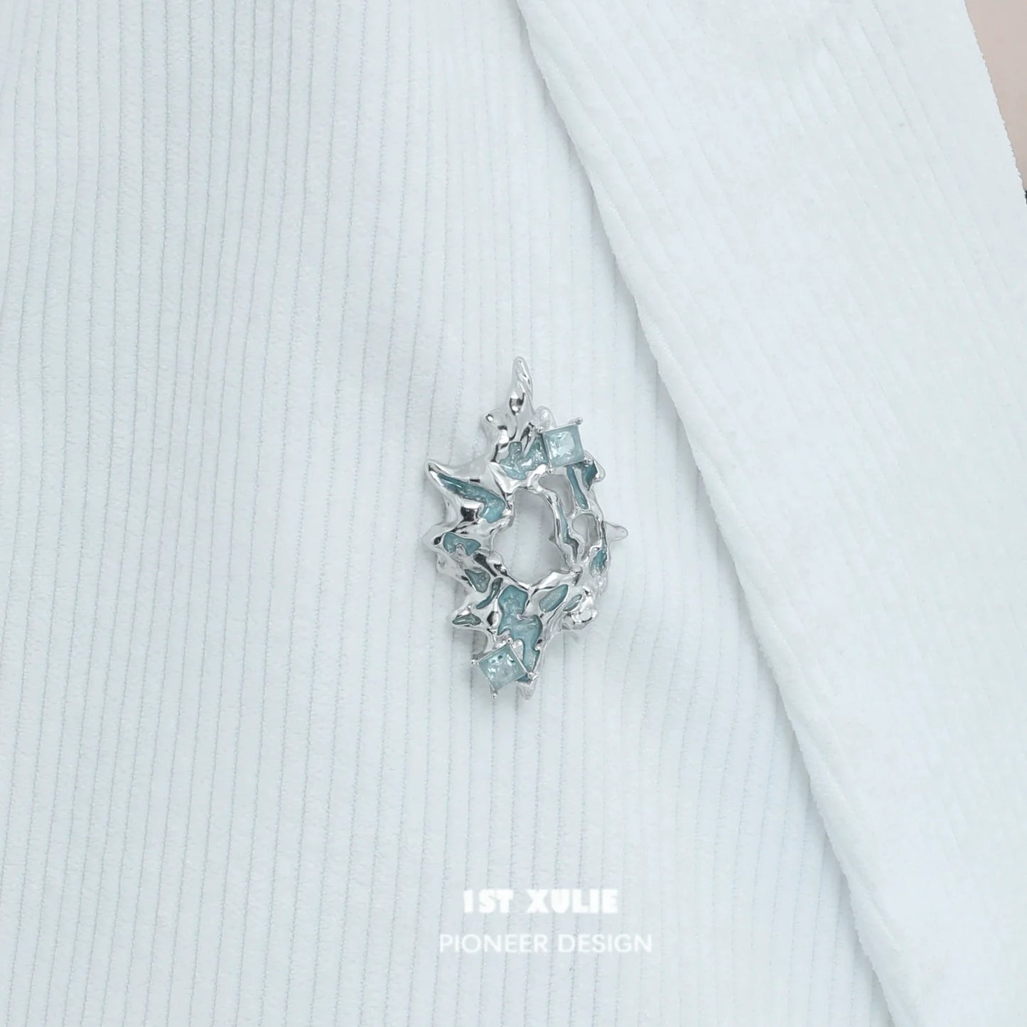 Elegant silver statement brooch featuring sparkling blue accents for stylish decor