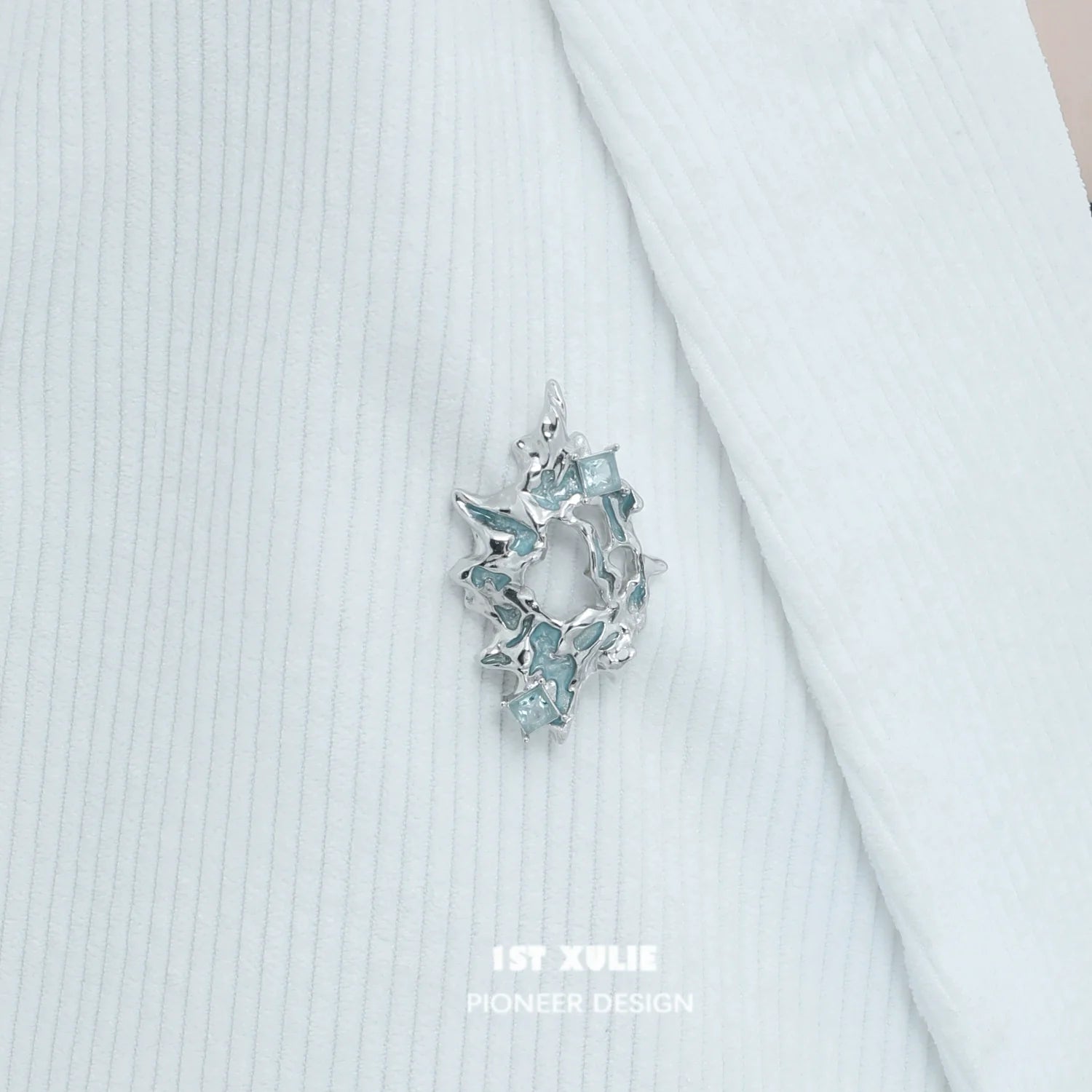 Elegant silver statement brooch featuring sparkling blue accents for stylish decor
